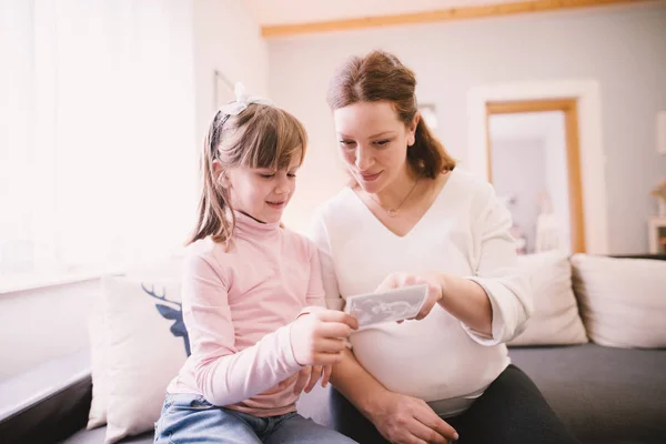 Lächelnde Schwangere Mutter Und Kleines Kleinkind Beim Betrachten Des Ultraschallbildes — Stockfoto