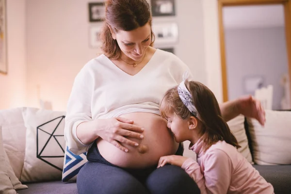 Pequeña Niña Besando Vientre Madre Embarazada —  Fotos de Stock