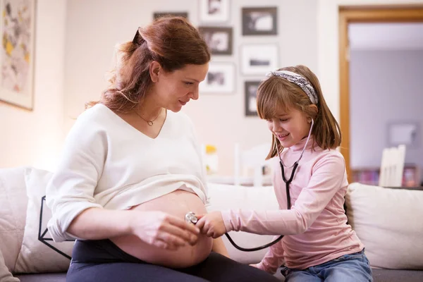 Söta Småbarn Flicka Lyssnande Magen Mamman Gravid Genom Stetoskop — Stockfoto