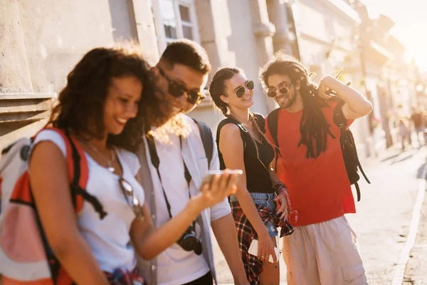 Dois Amigos Olhando Para Smartphone Junto Com Outro Casal Conversando — Fotografia de Stock