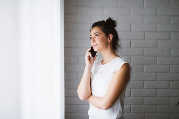 Mujer Pie Cerca Ventana Casa Hablando Por Teléfono Inteligente — Foto de Stock