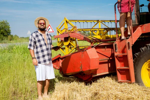 收割机附近麦田片的现代农民 — 图库照片