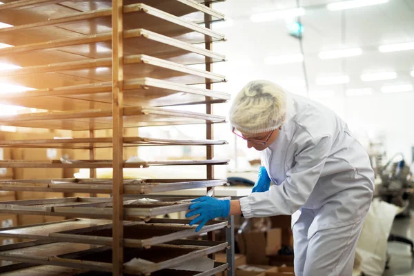 Jeune Femelle Travail Poussant Rack Avec Fer Blanc Rempli Biscuits — Photo