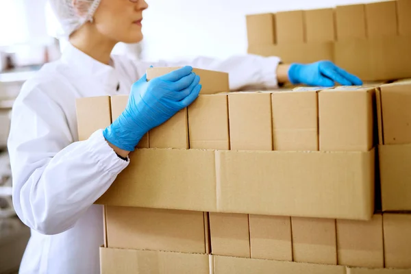 Jovem Operária Focada Contando Caixas Empilhadas Sala Armazenamento Fábrica — Fotografia de Stock