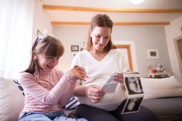 妊娠中の母親と幼児少女超音波スキャン画像を見て笑みを浮かべてください — ストック写真