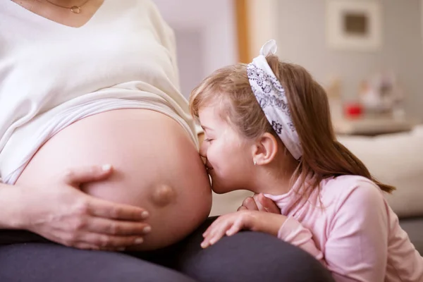 小さな幼児の女の子妊娠中の母親の腹にキス — ストック写真