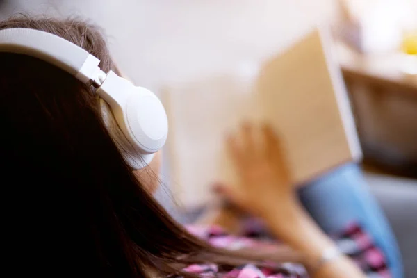 Młoda Piękna Kobieta Siedzi Czytanie Książki Słuchając Muzyki Słuchawkach — Zdjęcie stockowe
