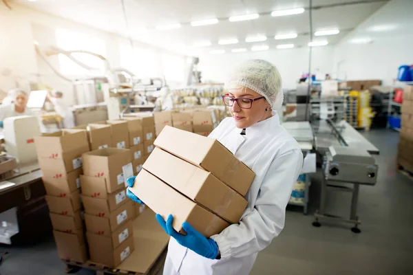 Junge Arbeiterin Trägt Schwere Stapel Brauner Kartons Aus Lagerraum — Stockfoto