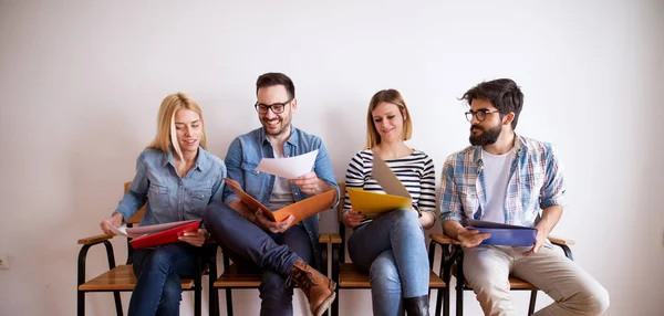 Grupo Jóvenes Sonrientes Confiados Sentados Fila Sala Espera Con Carpetas — Foto de Stock