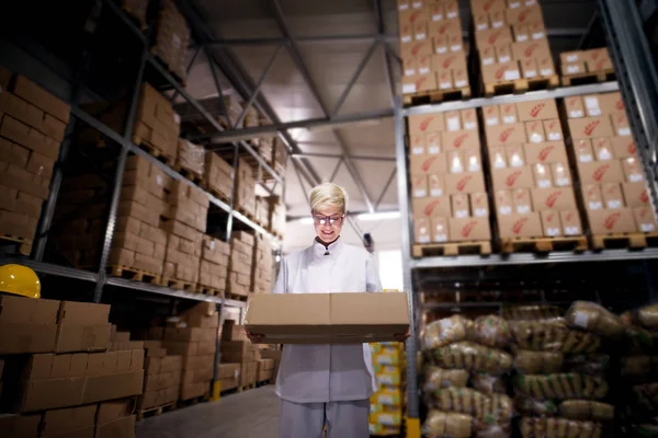 Junge Arbeiterin Trägt Schwere Stapel Brauner Kartons Aus Lagerraum — Stockfoto