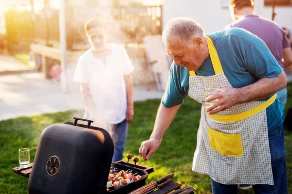 Älterer Glücklicher Mann Kocht Fleisch Grill — Stockfoto