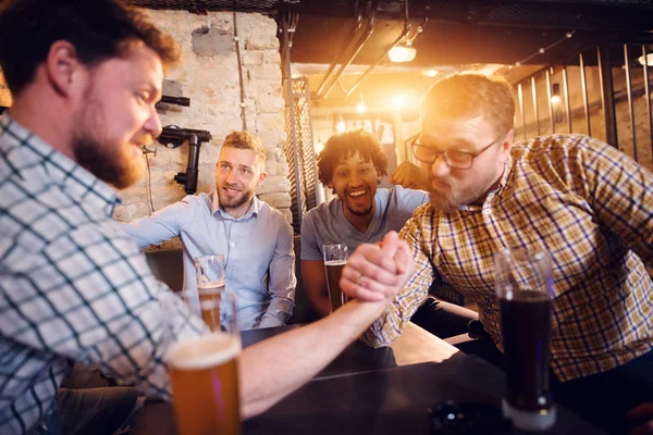 Jóvenes Hombres Felices Bebiendo Con Cerveza Pub Teniendo Desafío Lucha — Foto de Stock