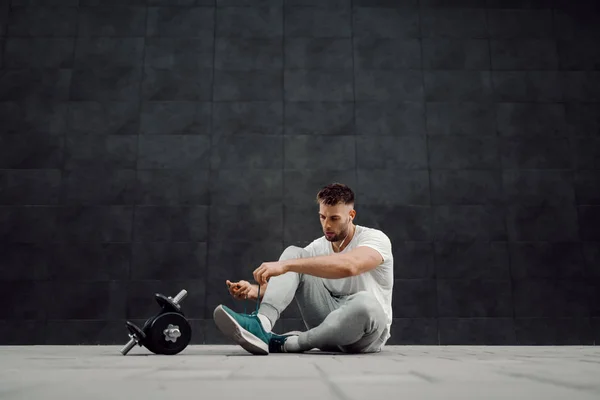 Musculoso Guapo Atleta Caucásico Chándal Camiseta Sentada Suelo Atando Cordones —  Fotos de Stock