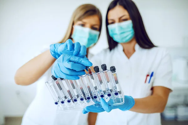 Two Dedicated Caucasian Lab Assistants Uniforms Masks Rubber Gloves Standing — Stock Photo, Image