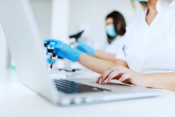 Close Assistente Laboratório Feminino Uniforme Branco Sentado Laboratório Usando Laptop — Fotografia de Stock