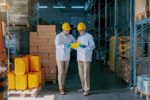 Dos Empleados Almacén Uniformes Blancos Con Cascos Amarillos Las Cabezas — Foto de Stock