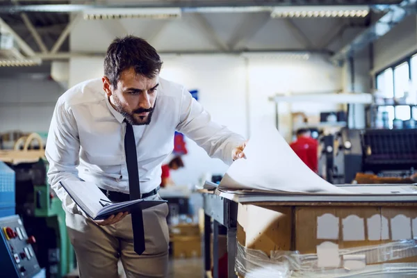Dedykowany Biały Inżynier Grafik Koszuli Krawacie Trzymający Notatnik Patrzący Arkusze — Zdjęcie stockowe