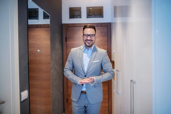 明るくハンサムな白人Unshavenスタイリッシュなビジネスマンスーツと眼鏡をホールに自宅に立って 仕事に行く準備 — ストック写真