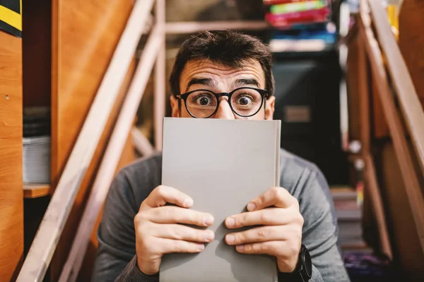Gözlüklü Yakışıklı Beyaz Adam Yüzünü Kitapla Kaplıyor Kameraya Bakıyor Kitapçının — Stok fotoğraf