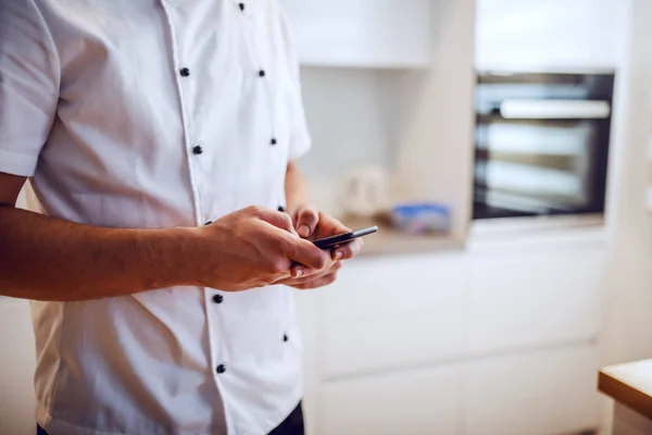 유니폼을 요리사 부엌에서 스마트폰을 사용하는 모습이 — 스톡 사진