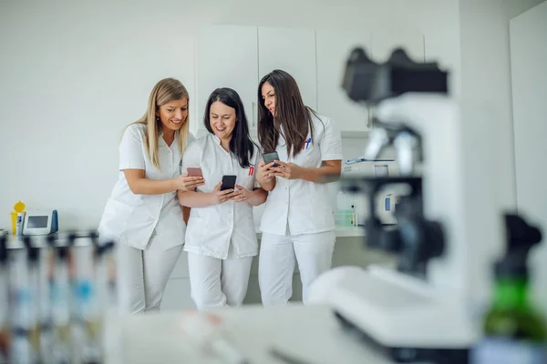 Három Mosolygós Vidám Fehér Női Laborasszisztens Fehér Egyenruhában Akik Laborban — Stock Fotó