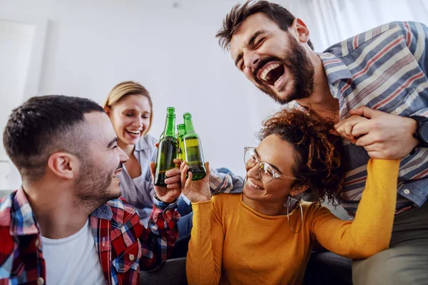 家で楽しくビールを飲みながら笑っている陽気な友達のグループ — ストック写真