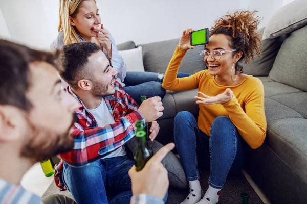 Grupo Alegres Amigos Juguetones Jugando Charadas Con Teléfono Inteligente Interior — Foto de Stock