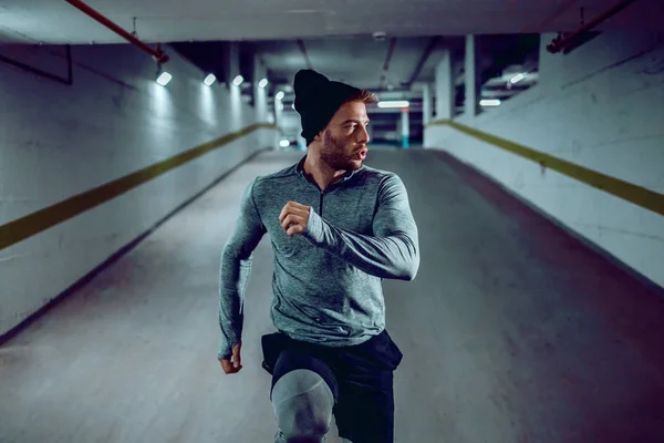 Kendini Işine Adamış Güçlü Beyaz Tenli Sporcu Yeraltı Garajında Koşuyor — Stok fotoğraf
