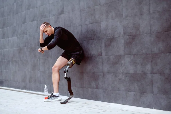 Αναστατωμένος Όμορφος Καυκάσιος Αθλητής Τεχνητό Πόδι Ακουμπισμένο Στον Τοίχο Κρατώντας — Φωτογραφία Αρχείου