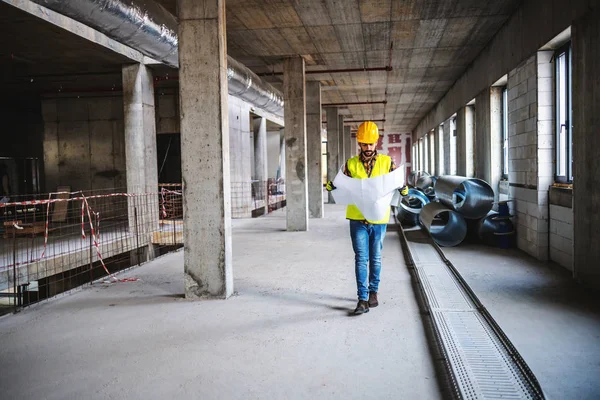 Nşaat Işindeki Tam Uzunluktaki Işçiler Inşaat Aşamasında Yürürken Bina Planlarına — Stok fotoğraf