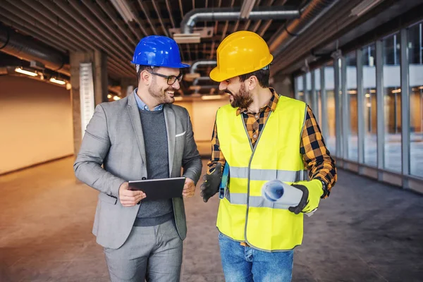 Trabalhador Construção Sorrindo Desgaste Trabalho Segurando Plantas Conversando Com Arquiteto — Fotografia de Stock