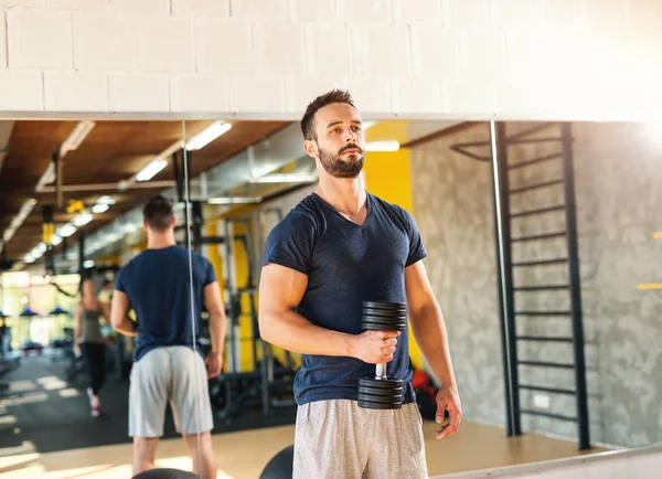 Muscular Serious Man Sportswear Holding Dumbbell Background His Reflection Mirror — Stok fotoğraf