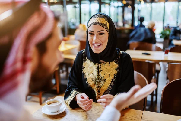 迷人的微笑的阿拉伯女人穿着传统的衣服 和她心爱的丈夫坐在咖啡店里 在周末度过美好的时光 桌上有一杯咖啡 多样性概念 — 图库照片