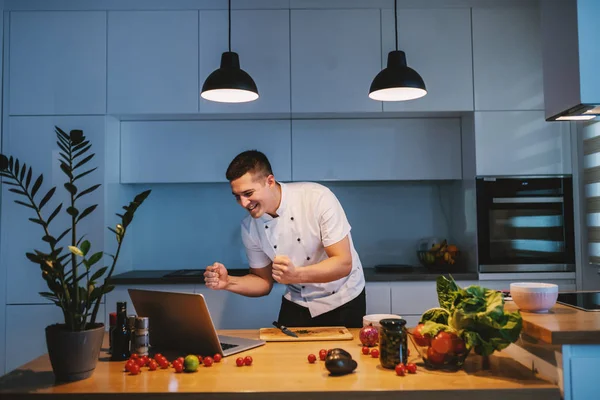 Chef Caucasiano Feliz Uniforme Branco Cozinha Olhando Para Laptop Balcão — Fotografia de Stock