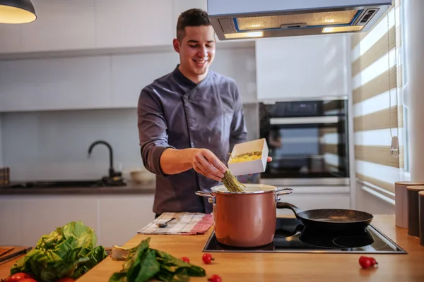 Joven Feliz Sonriente Chef Caucásico Uniforme Poniendo Pasta Olla Con — Foto de Stock