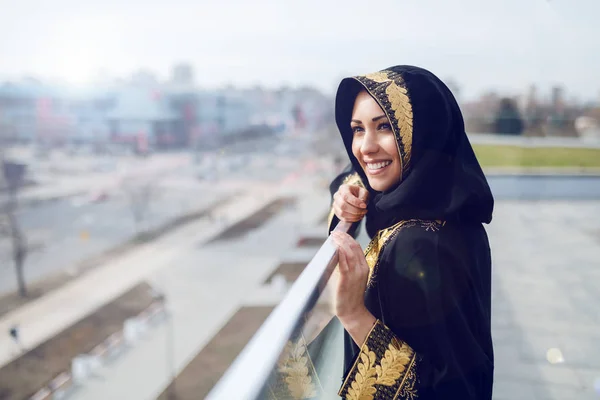 屋上に立ちながら美しい景色を眺めながら伝統的な服を着た豪華なイスラム教徒の女性 — ストック写真
