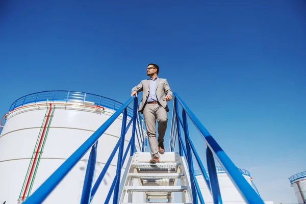 Takım Elbiseli Yakışıklı Beyaz Adamı Merdivenlerden Inip Rafinerisine Bakıyor Arka — Stok fotoğraf