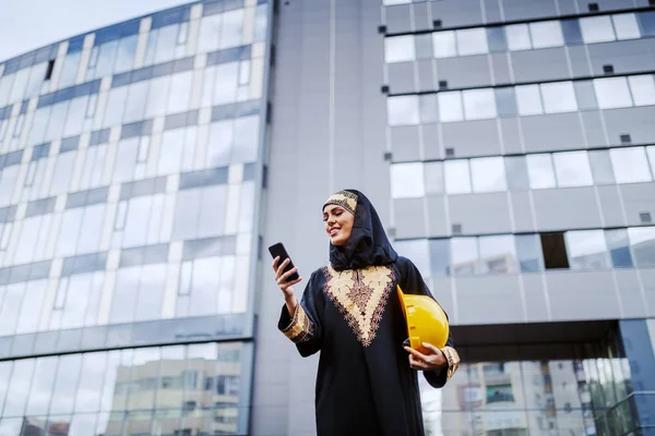 Atractiva Mujer Musulmana Sonriente Pie Frente Edificio Corporativo Usando Teléfono — Foto de Stock