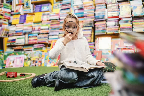 Schattig Klein Meisje Zittend Vloer Boekenwinkel Met Boek Schoot Kijkend — Stockfoto