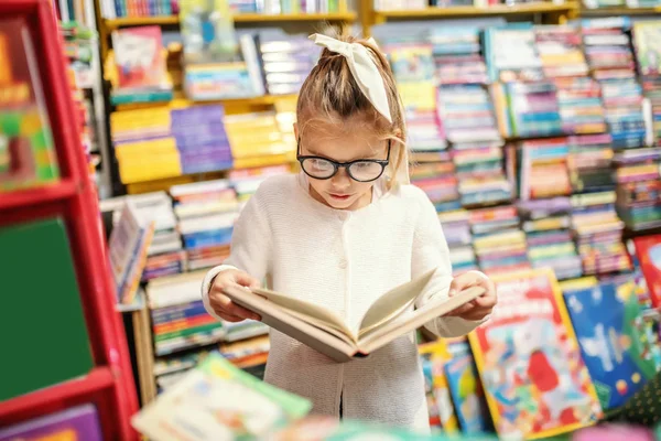 Adorable Curious Caucasian Little Girl Eyeglasses Standing Bookstore Reading Interesting — 스톡 사진