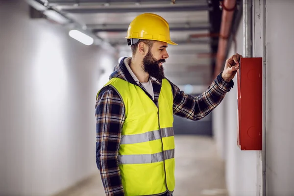 Genç Yakışıklı Sakallı Elektrikçi Yeniden Inşa Sürecinde Binada Duruyor Dağıtım — Stok fotoğraf