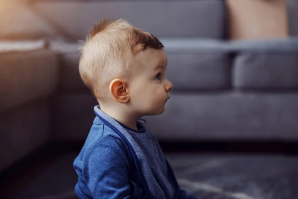 Profilja Imádnivaló Szőke Kisfiú Padlón Otthon Kíváncsian Nézett Valamit — Stock Fotó