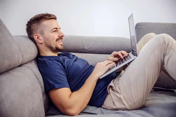 Tampilan Samping Menarik Tersenyum Pria Berjenggot Berbaring Sofa Dan Menggunakan — Stok Foto