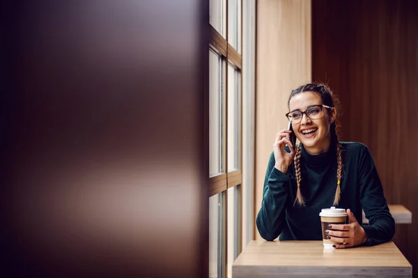 Vrolijke Glimlachende Jonge Vrouw Zittend Cafetaria Telefoongesprek Voeren Wegwerpbeker Vasthouden — Stockfoto