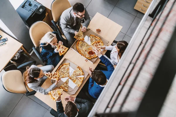 Верхний Вид Голодных Коллег Сидящих Столом Обедающих Пиццей Корпоративный Интерьер — стоковое фото