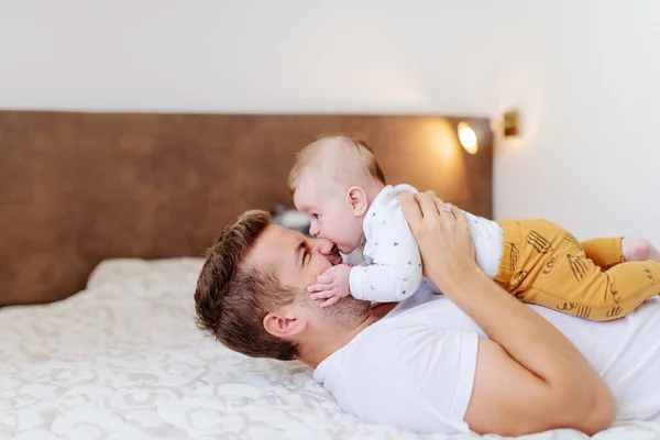 Sonriente Padre Guapo Caucásico Acostado Cama Dormitorio Sosteniendo Adorable Hijo —  Fotos de Stock