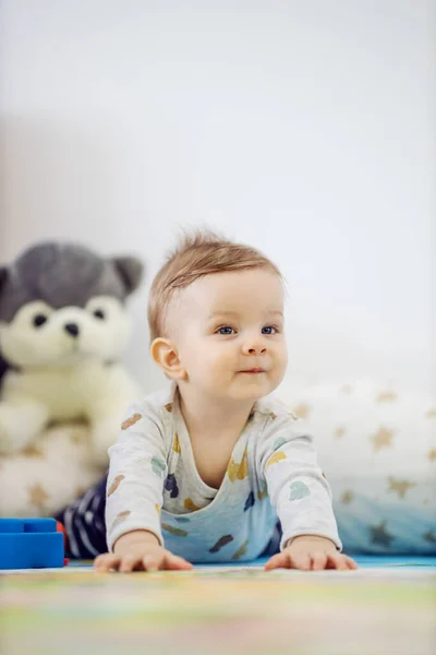 かわいい金髪の小さな男の子と美しい青い目のクロール方法を学ぶ ホームインテリア — ストック写真