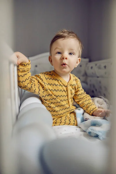 Puzzled Schattige Blonde Kleine Jongen Zitten Zijn Wieg Ochtend Voor — Stockfoto