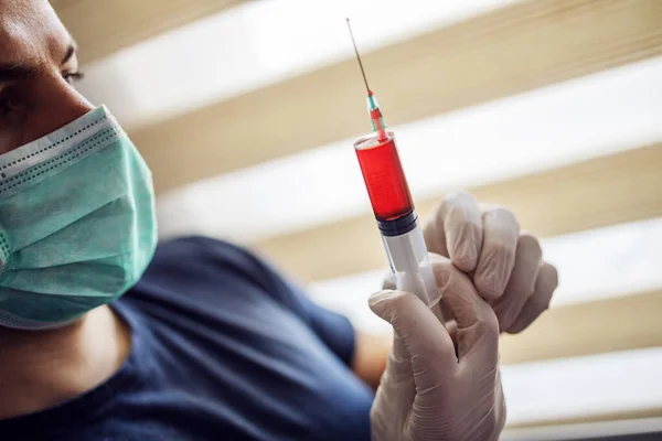 Jovem Com Máscara Luvas Olhar Para Injecção Cheia Sangue Responsável — Fotografia de Stock