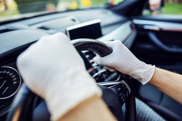 Man with protective mask and gloves driving a car. Infection prevention and control of epidemic. World pandemic. Stay safe.